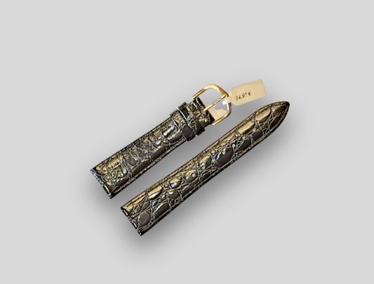 Gold and black patterned watch strap on a light gray background