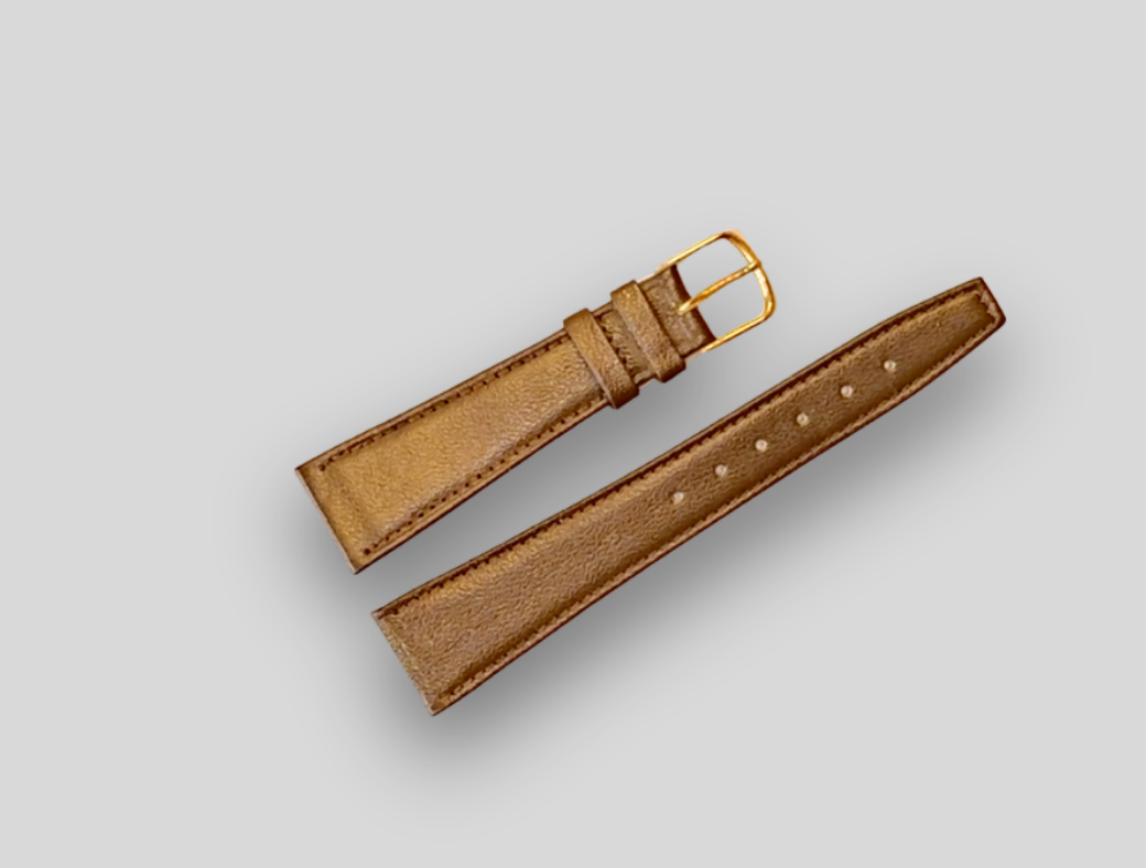 Brown leather watch strap with gold buckle on a light gray background