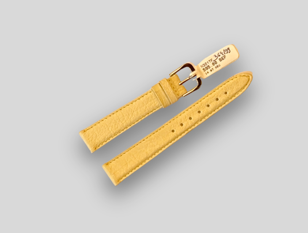 Yellow watch strap with gold buckle on a gray background