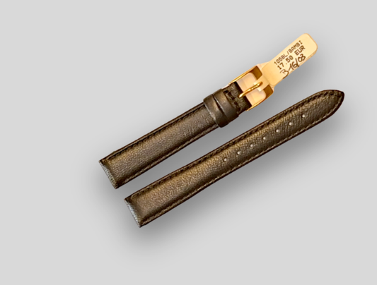 Brown watch strap with gold buckle on a light gray background