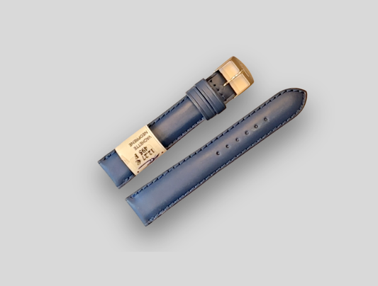 Blue ZRC watch strap with gold clasp on a light gray background