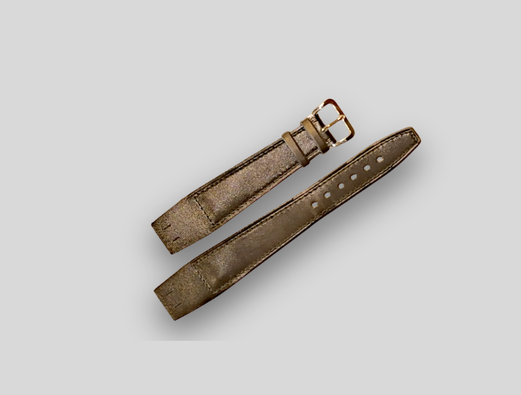 Brown leather watch strap with gold buckle on a light gray background