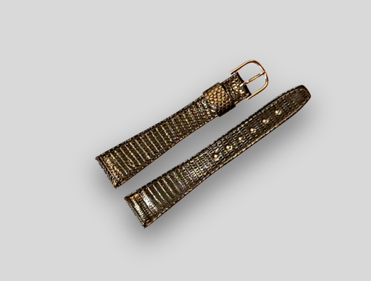 Gold watch strap on a light gray background