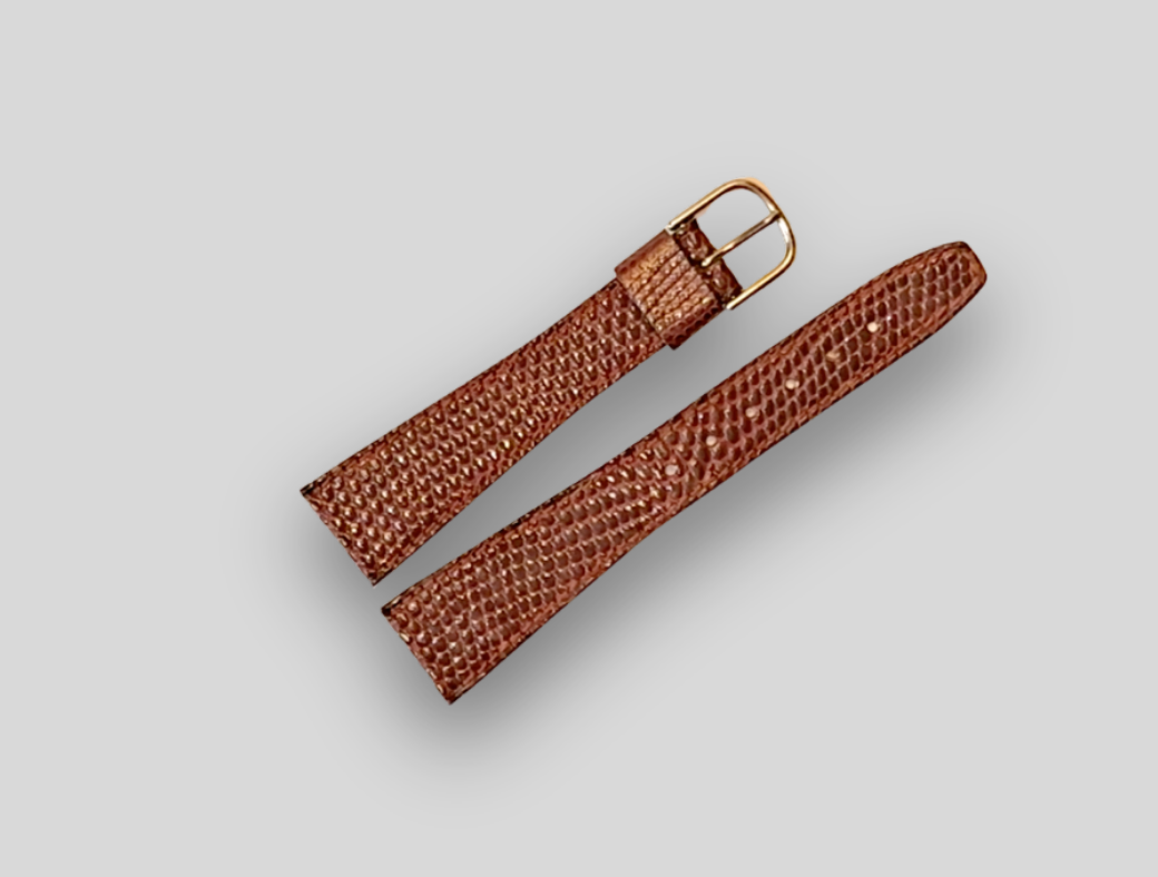 Brown lizard watch strap with gold buckle on a light gray background