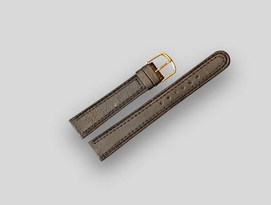 Gray leather watch strap with gold buckle on a light gray background