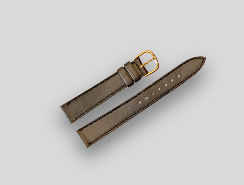Brown leather watch strap with gold buckle on a light gray background