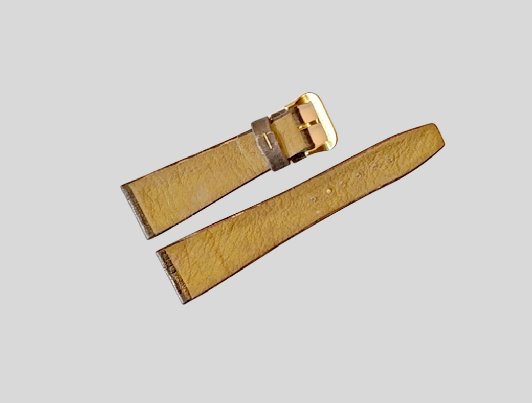 Beige leather watch strap with gold buckle on a light gray background