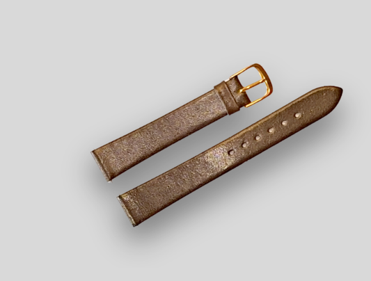 Brown leather watch strap with gold buckle on a light gray background