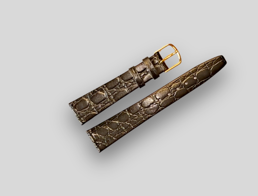 Brown crocodile-patterned watch strap with gold buckle on a light gray background